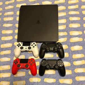 Sony PlayStation Console with Black, White, and Red Controllers